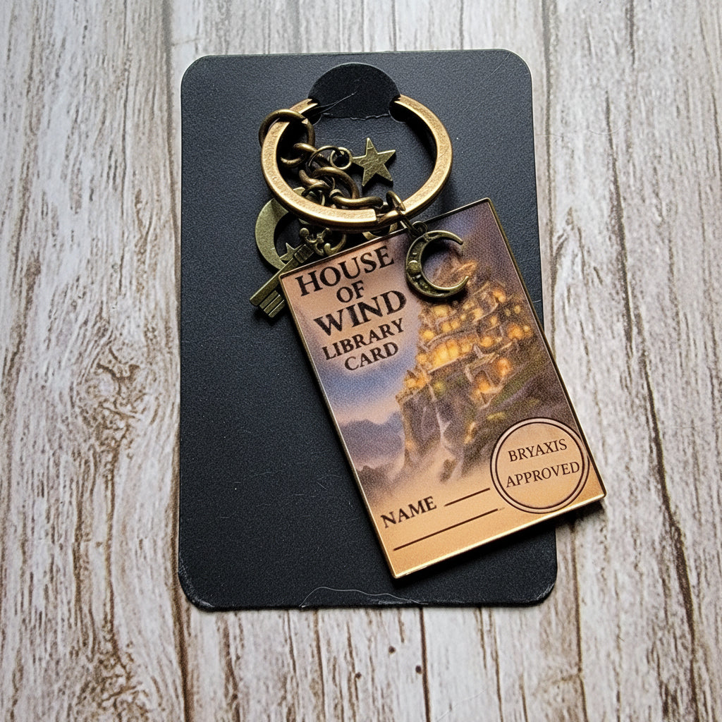 Decorative keychain with 'House of Wind' library card design on a wooden surface
