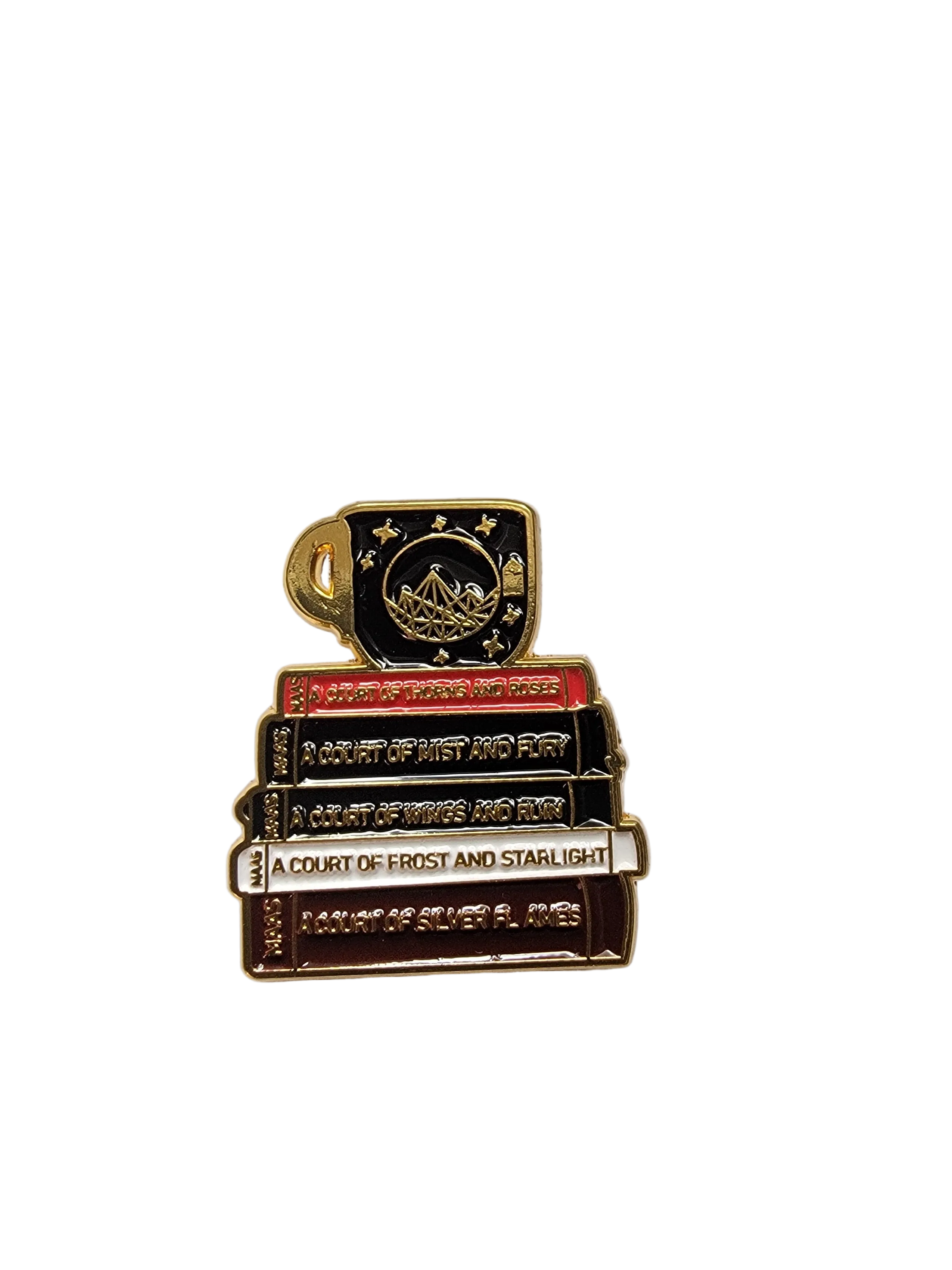 Small decorative item resembling books with gold accents on a white surface, next to a quarter for scale.
