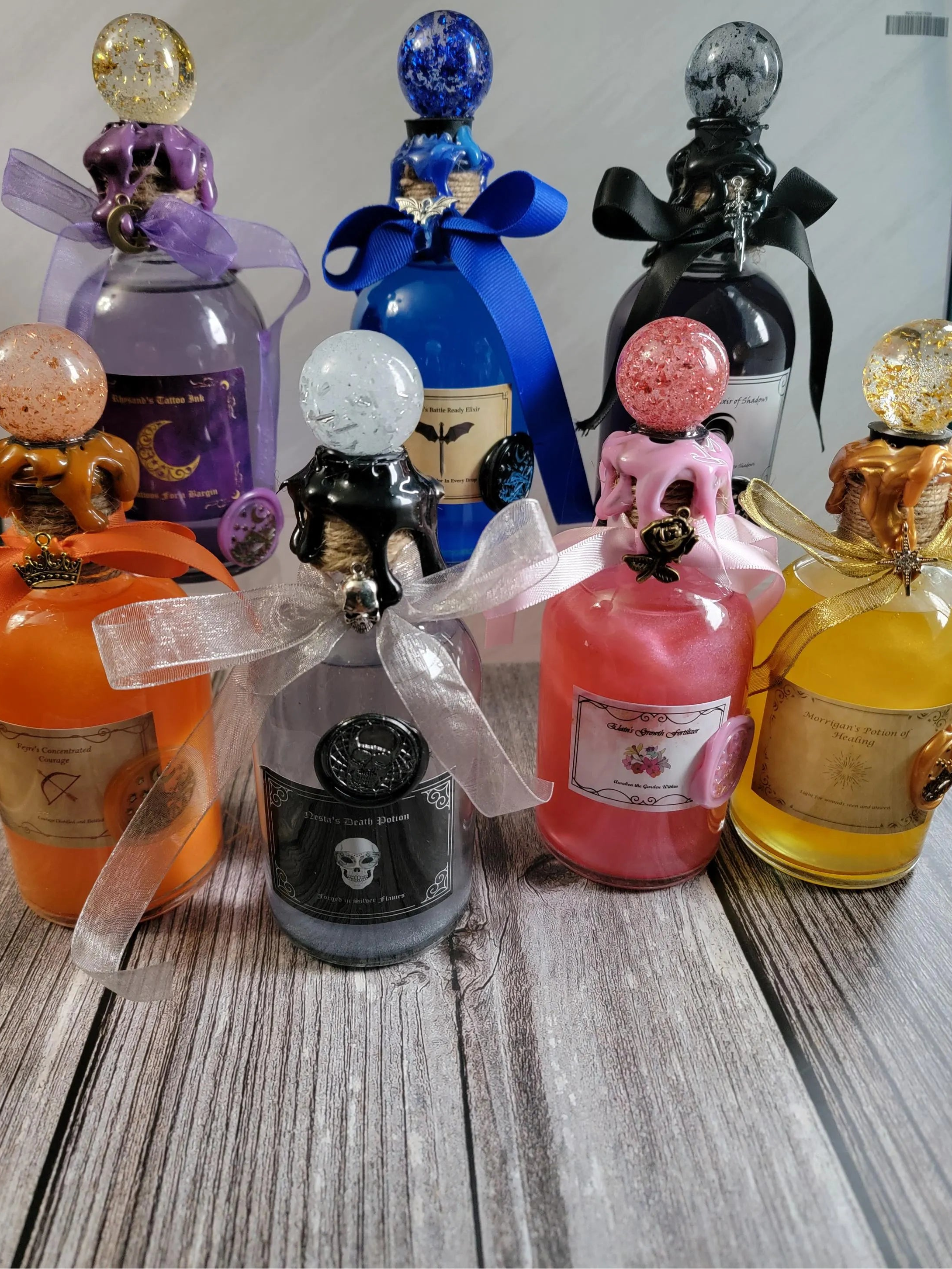 Colorful bottles with decorative tops on a wooden surface