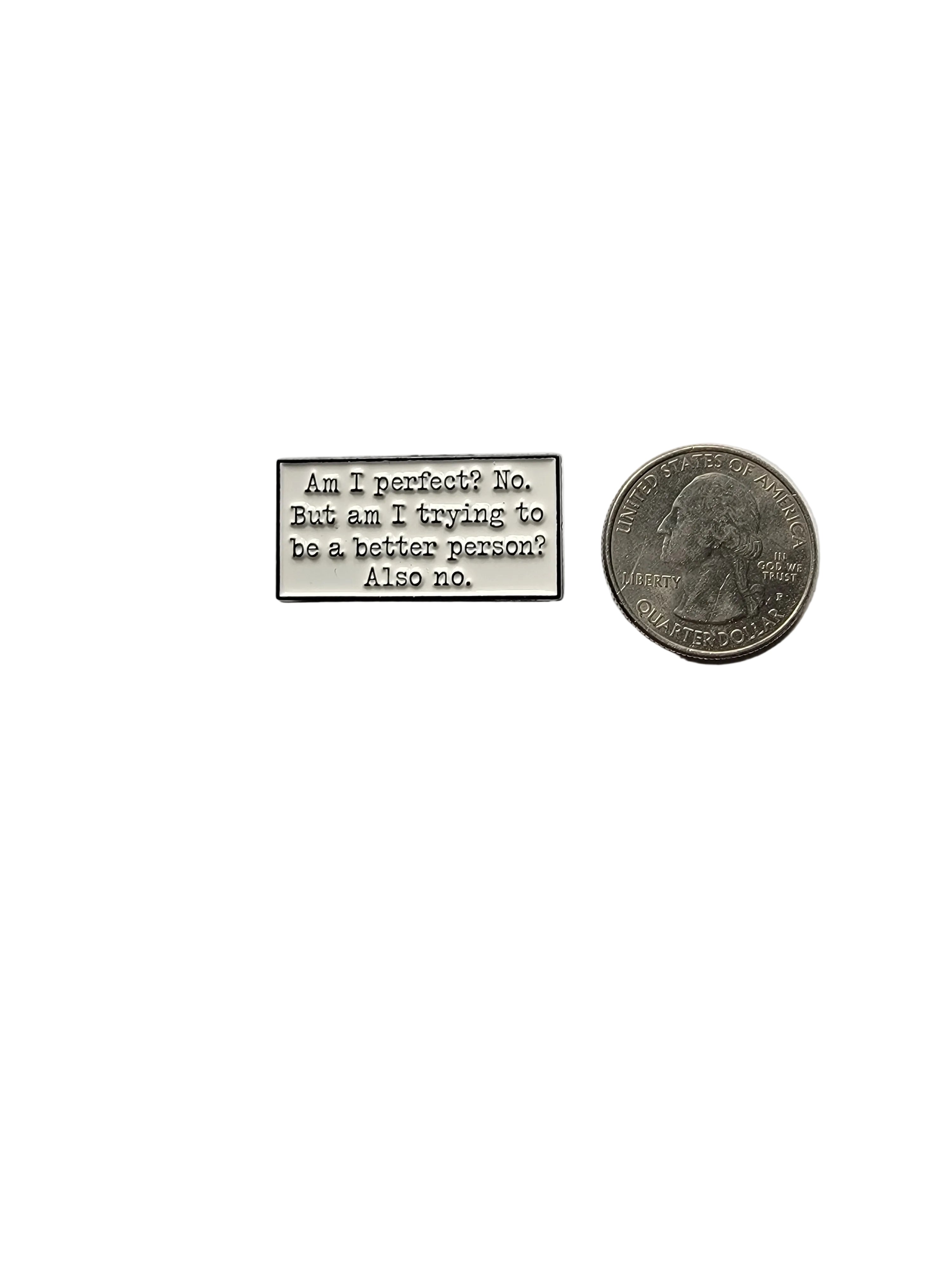 Small metal block with engraved text next to a coin on a gray background