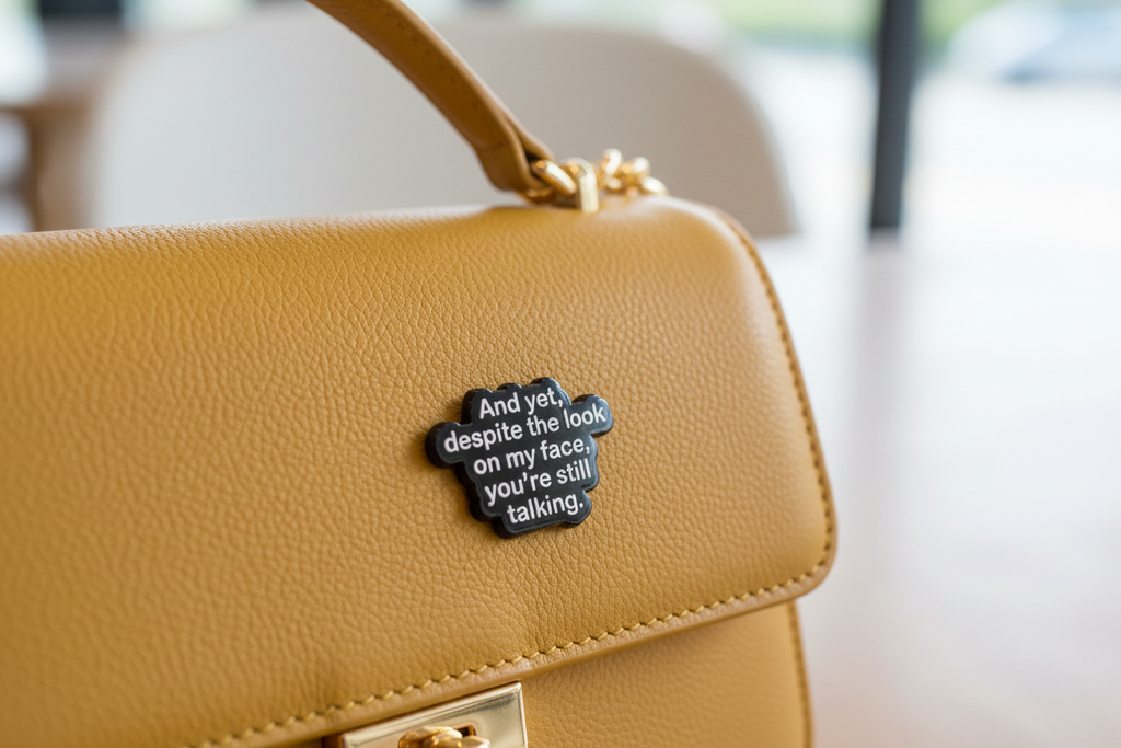 Black and white text pin on a yellow purse