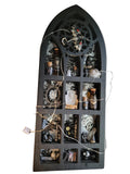 Decorative wall shelf with gothic arch design filled with small decorative items on a gray background.