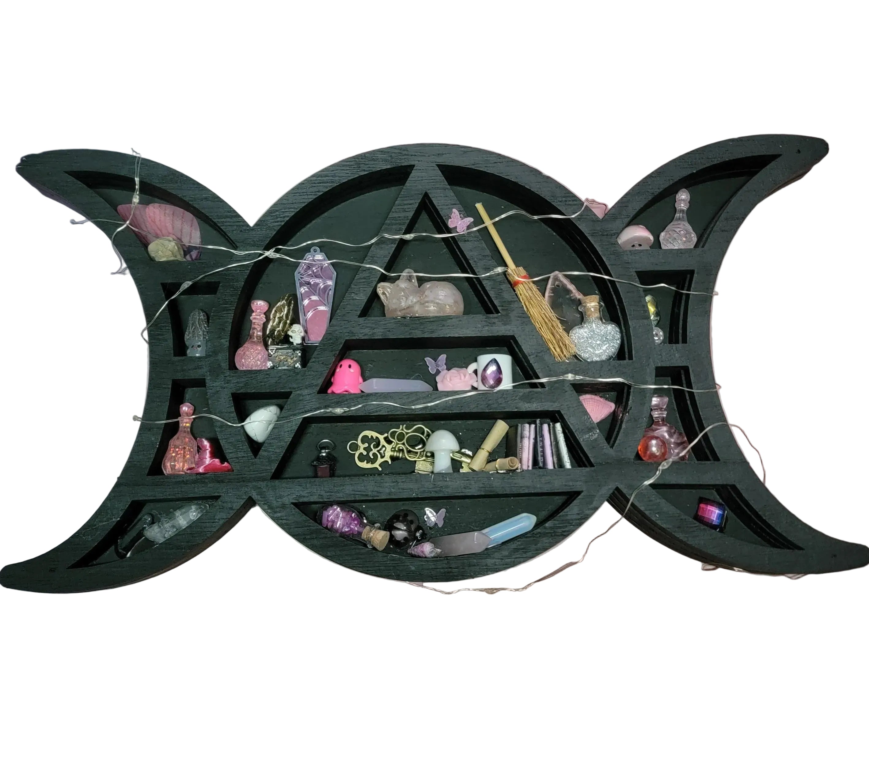 Witchy shelf with various decorative items against a pink and white striped background