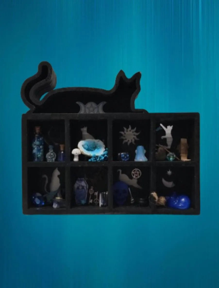 Black cat-shaped shelf with various small figurines against a blue background