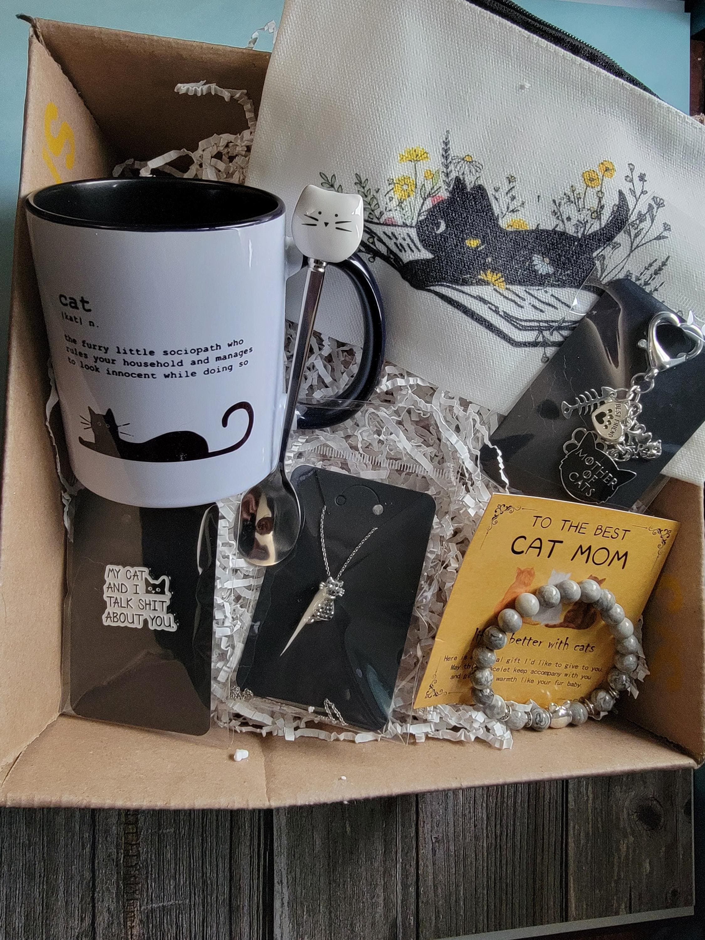 Gift box with cat-themed items including a mug, necklace, and keychain.