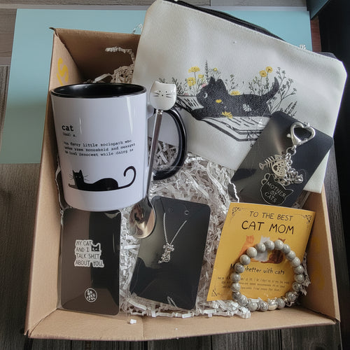 Gift box with cat-themed items including a mug, necklace, and keychain.