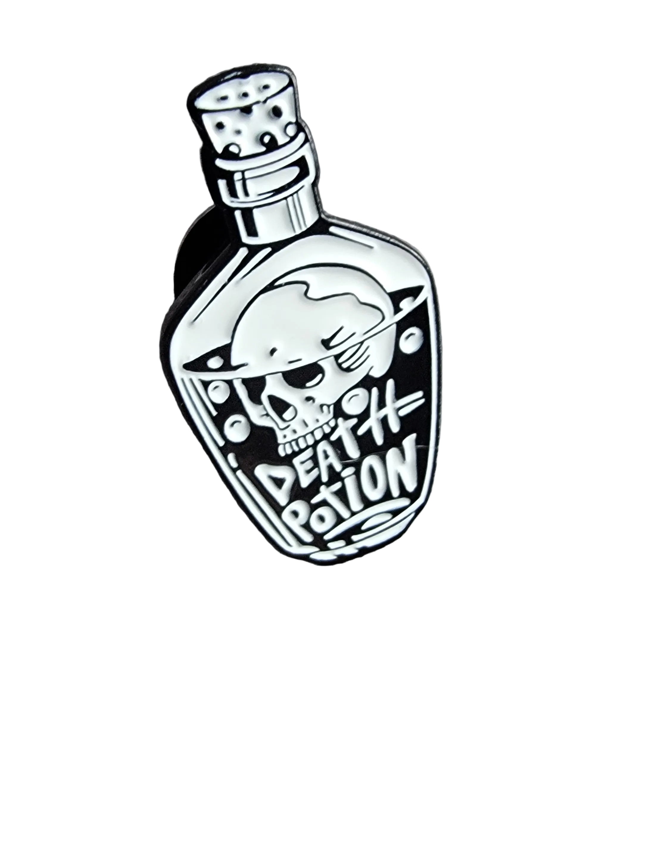 Enamel pin of a potion bottle labeled 'Death Potion' on a wooden surface