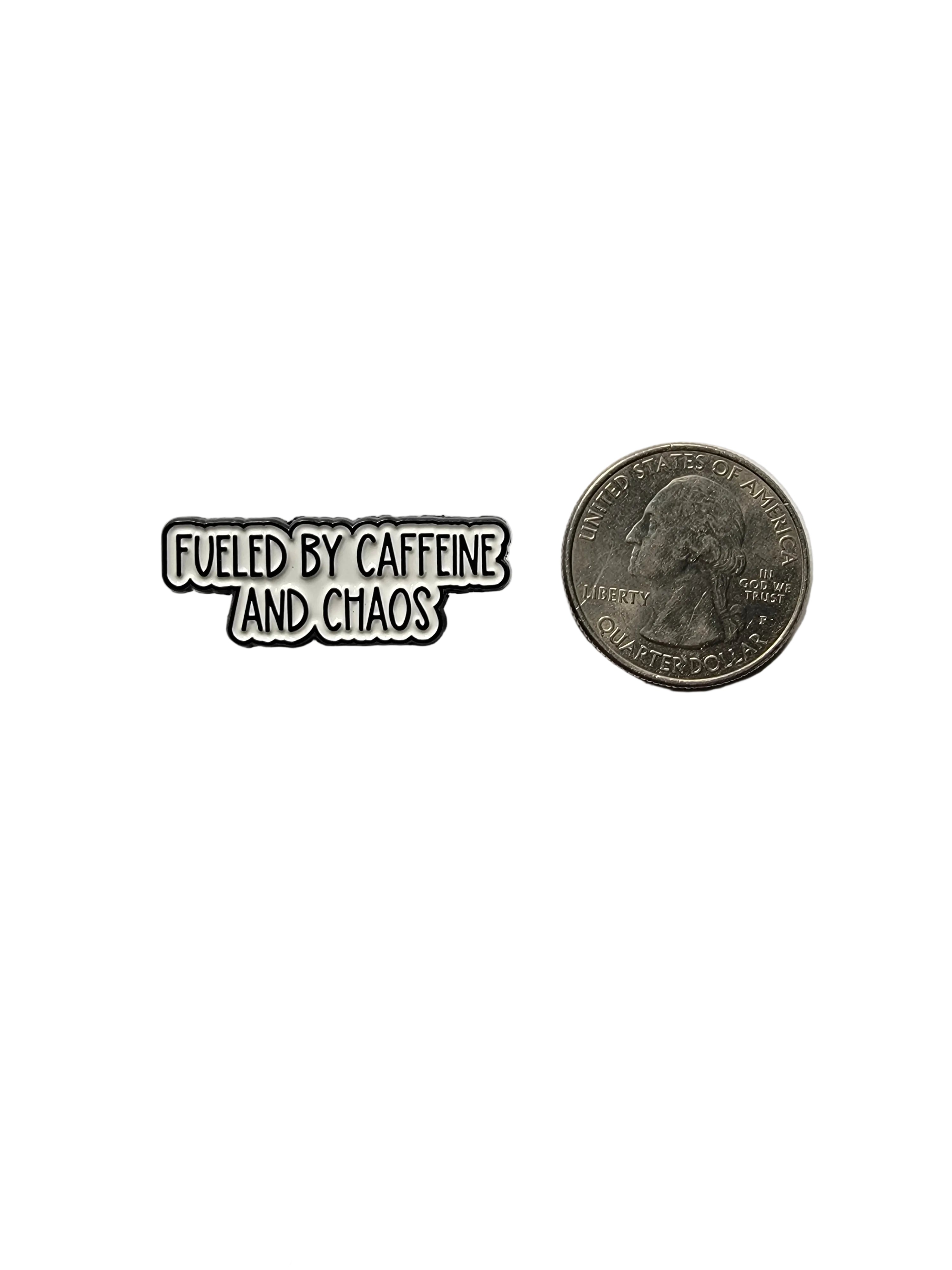 Pin with 'Fueled by Caffeine and Chaos' text next to a coin on a gray background