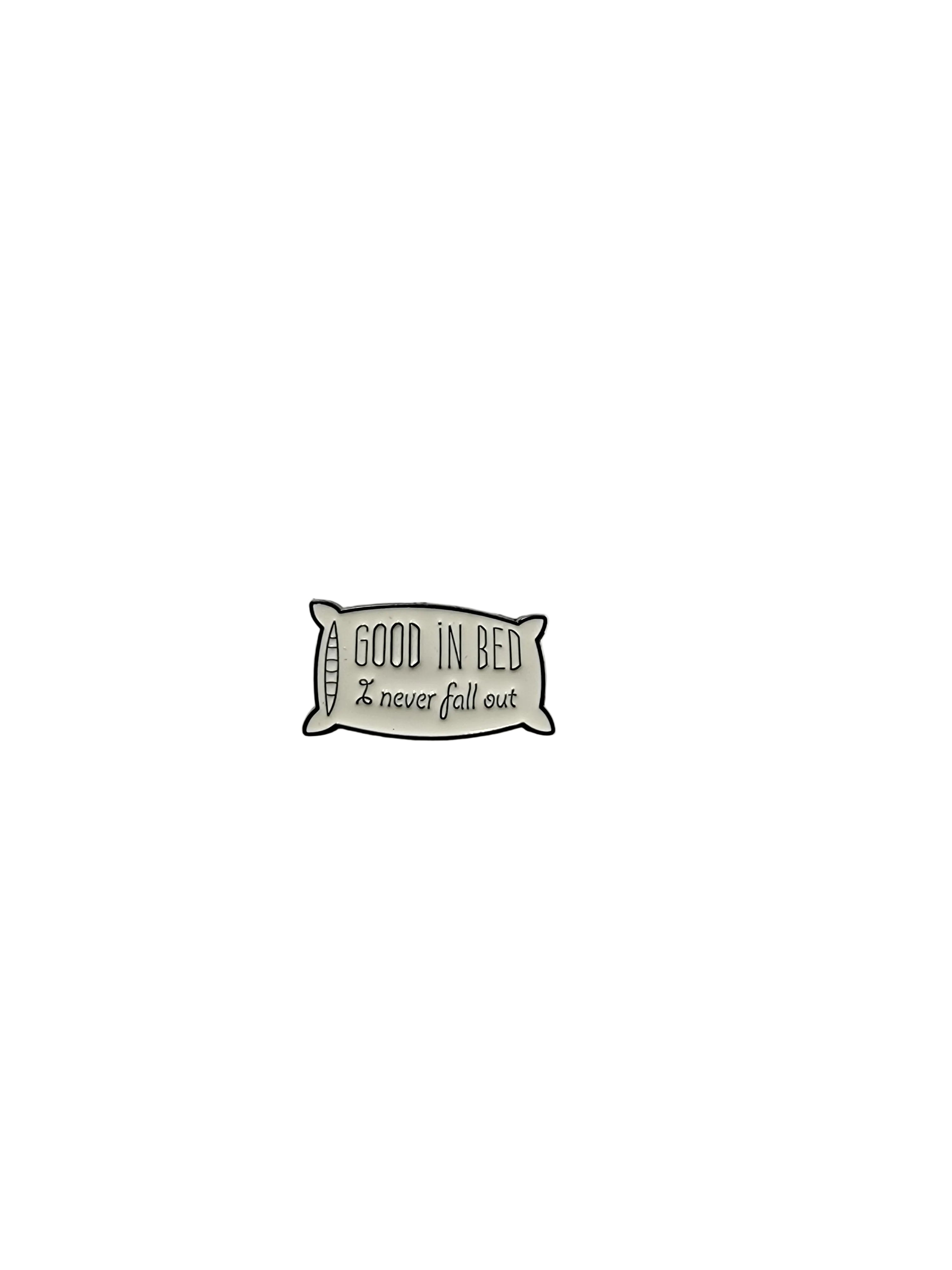 Small pillow-shaped enamel pin with 'Good in Bed' text on a plain background