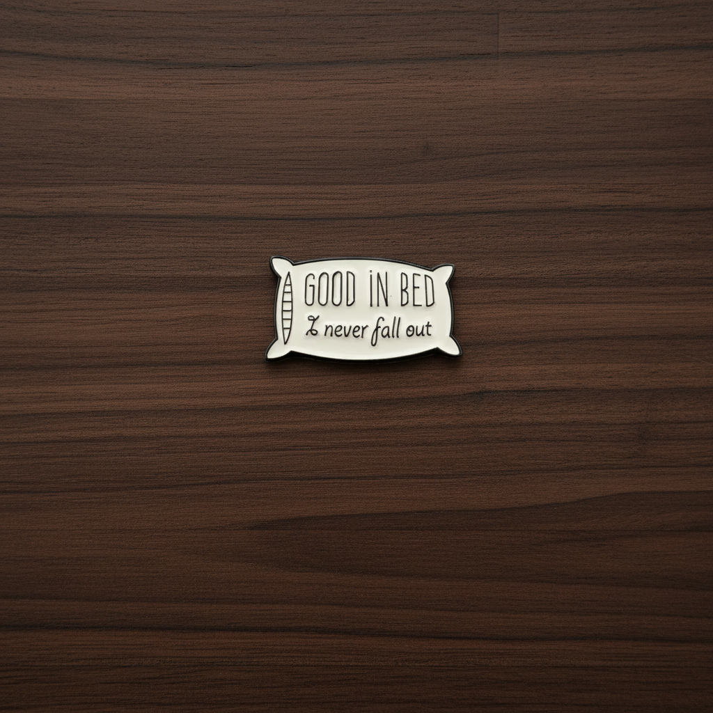 Good in bed enamel pin on wood background dad humor enamel pin with pillow detail