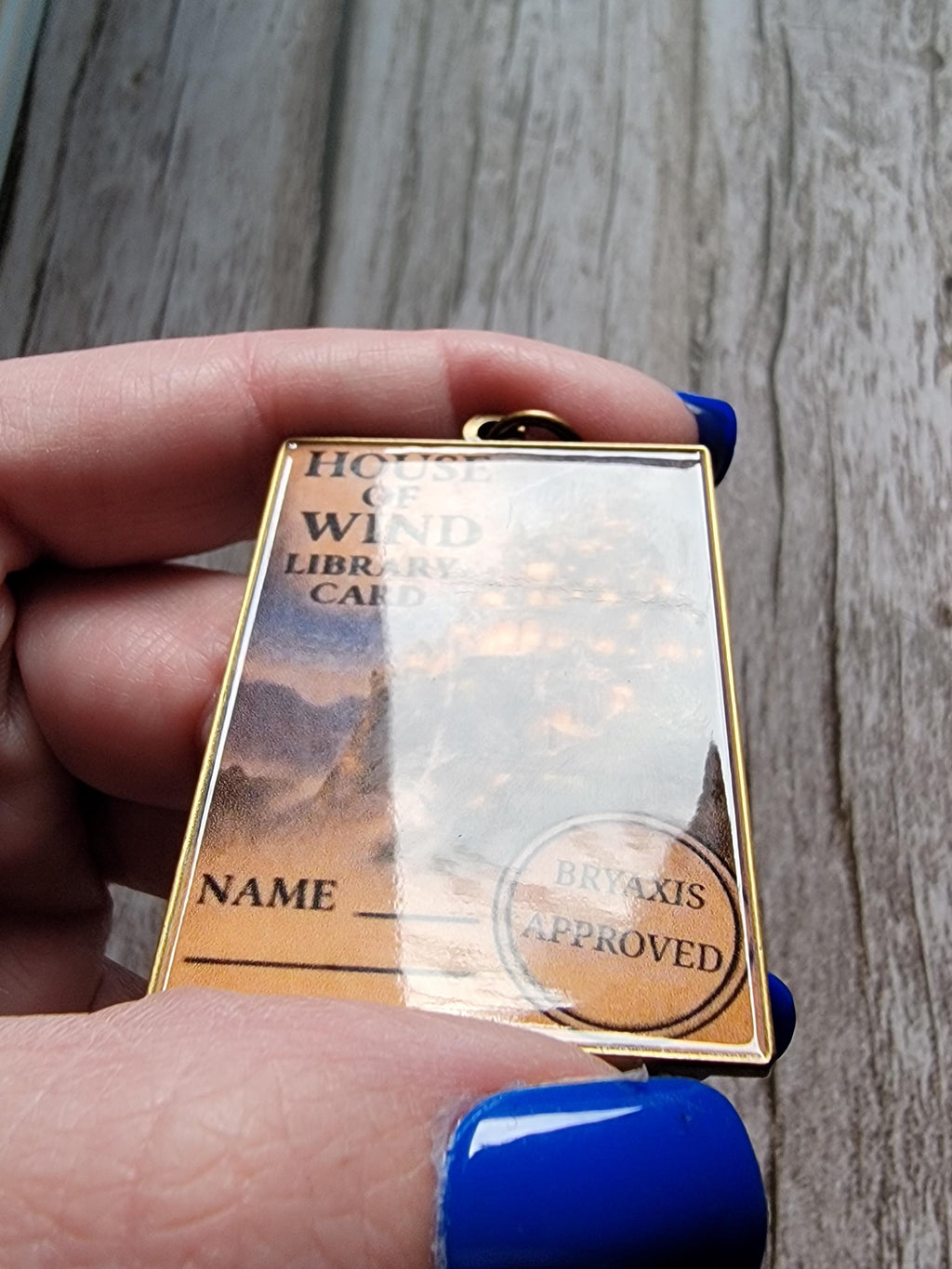 ACOTAR inspired keychain on a wood surface with a high reflective surface. 