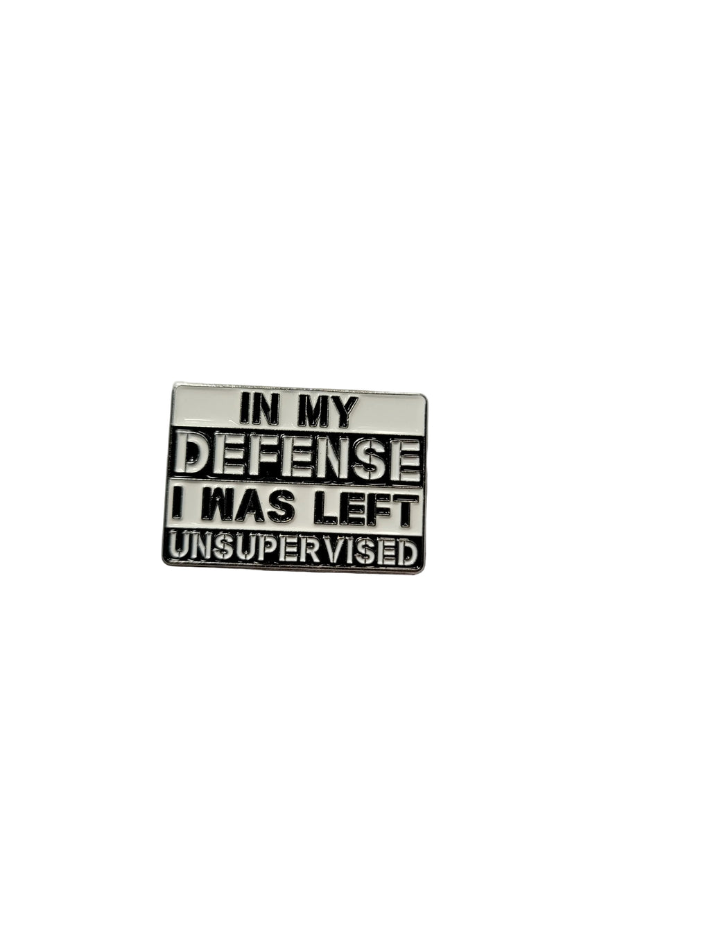 a square metal pin that is white and black with text