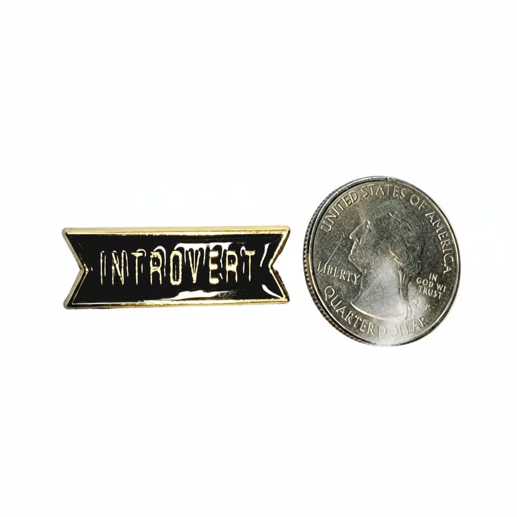 Introvert enamel pin shown next to quarter for size reference sarcastic enamel pin dims 1 inch wide x 0.25 inches high