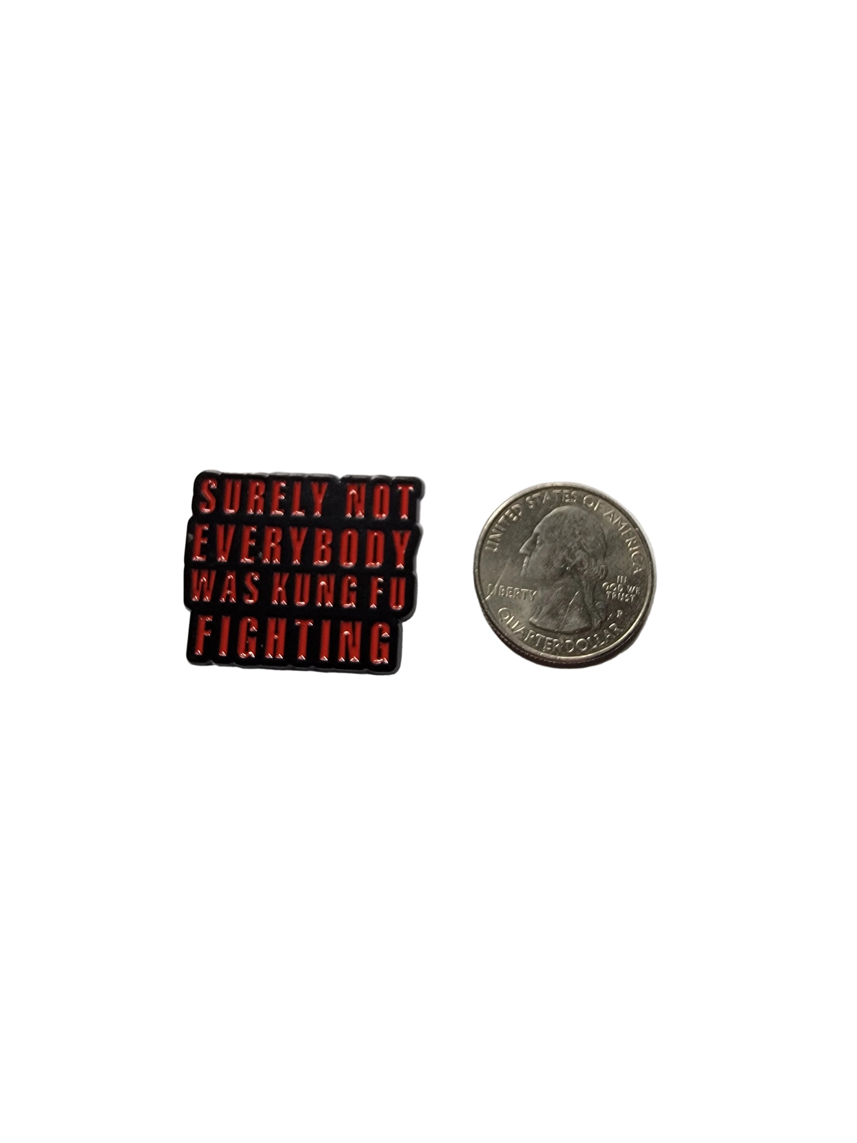 Small red and black rectangular object with text next to a coin on a gray background