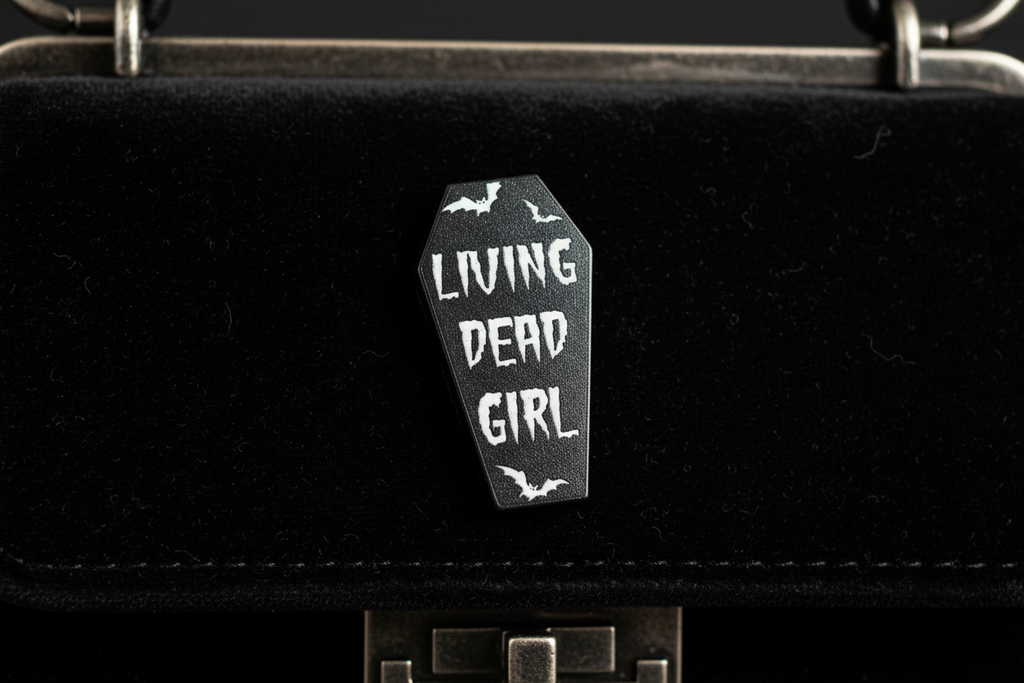 Living Dead Girl Enamel Pin attached to purse Halloween brooch accessory for bags and personal style
