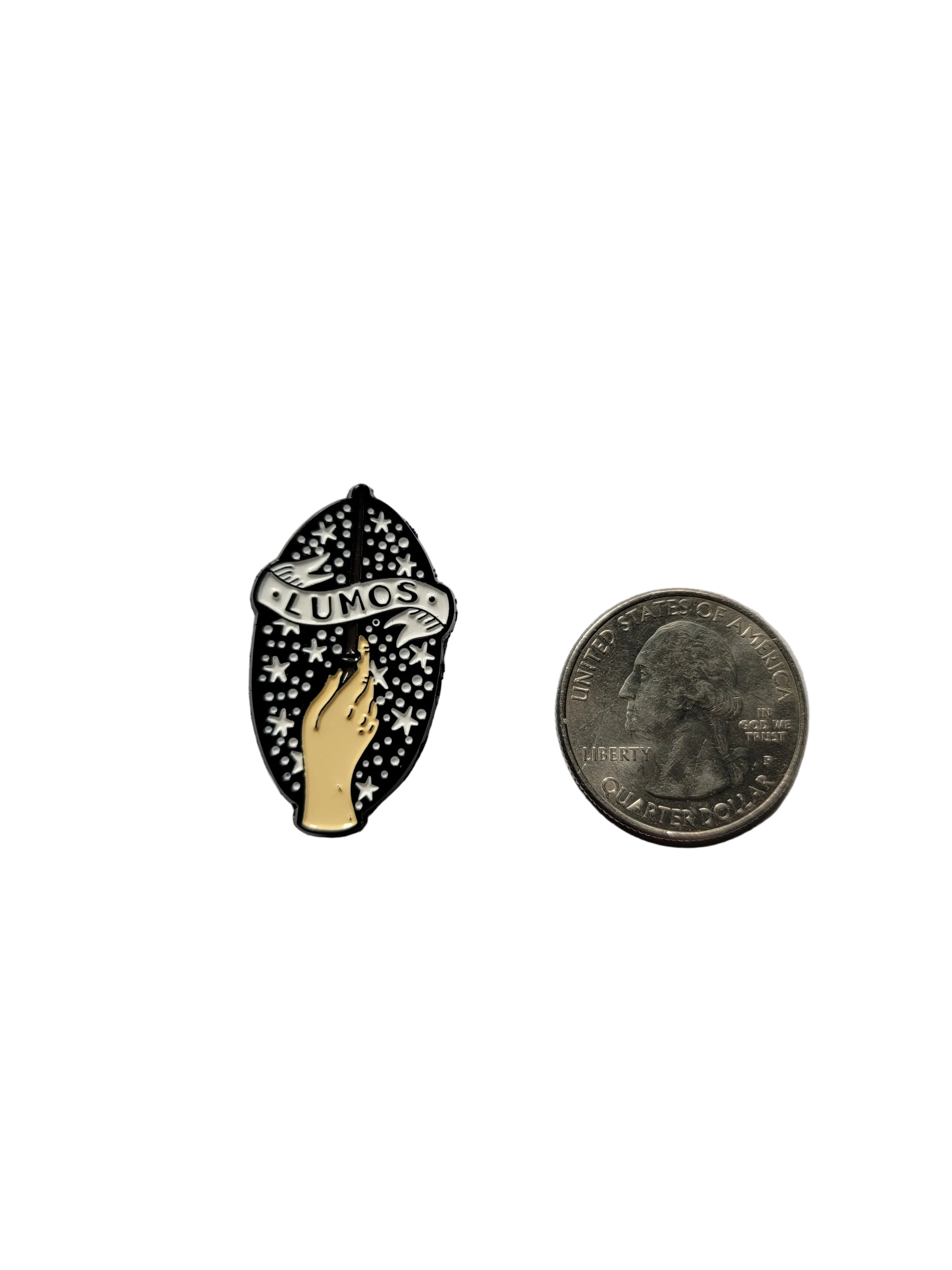 Lumos Enamel Pin shown next to quarter for size reference magical enamel pin dims 7 /8 in W x 1 1/8 in H