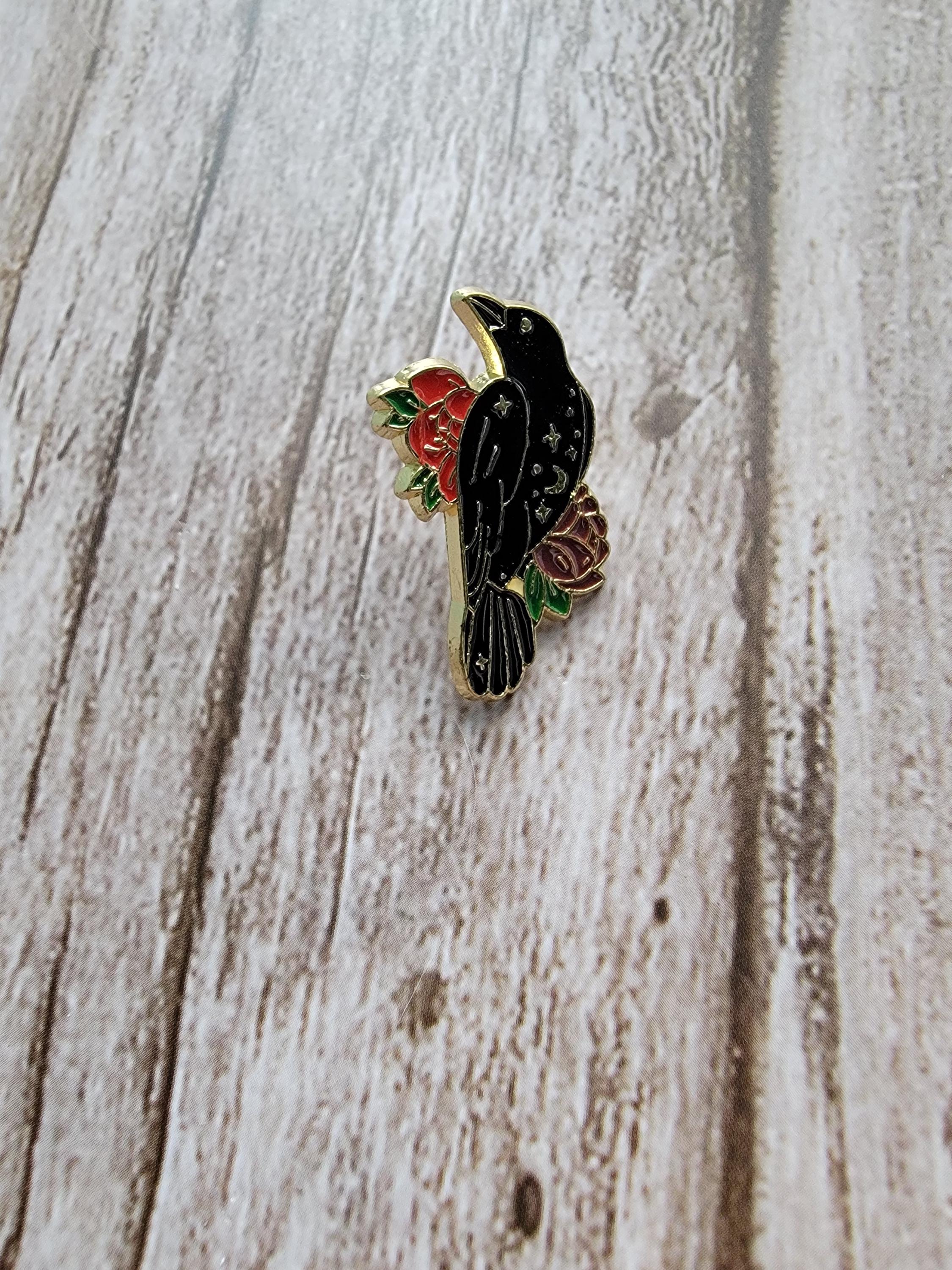 Mystical Crow Enamel Pin on wood background witch enamel pin with raven and red and purple flower detail
