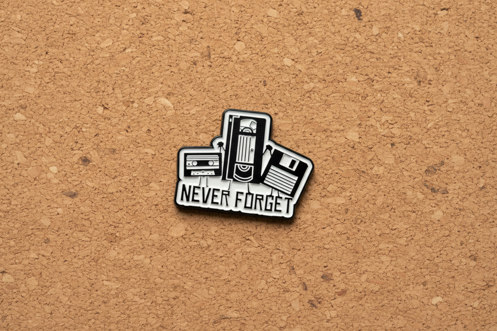 Pin with cassette tape design and 'Never Forget' text on a cork background