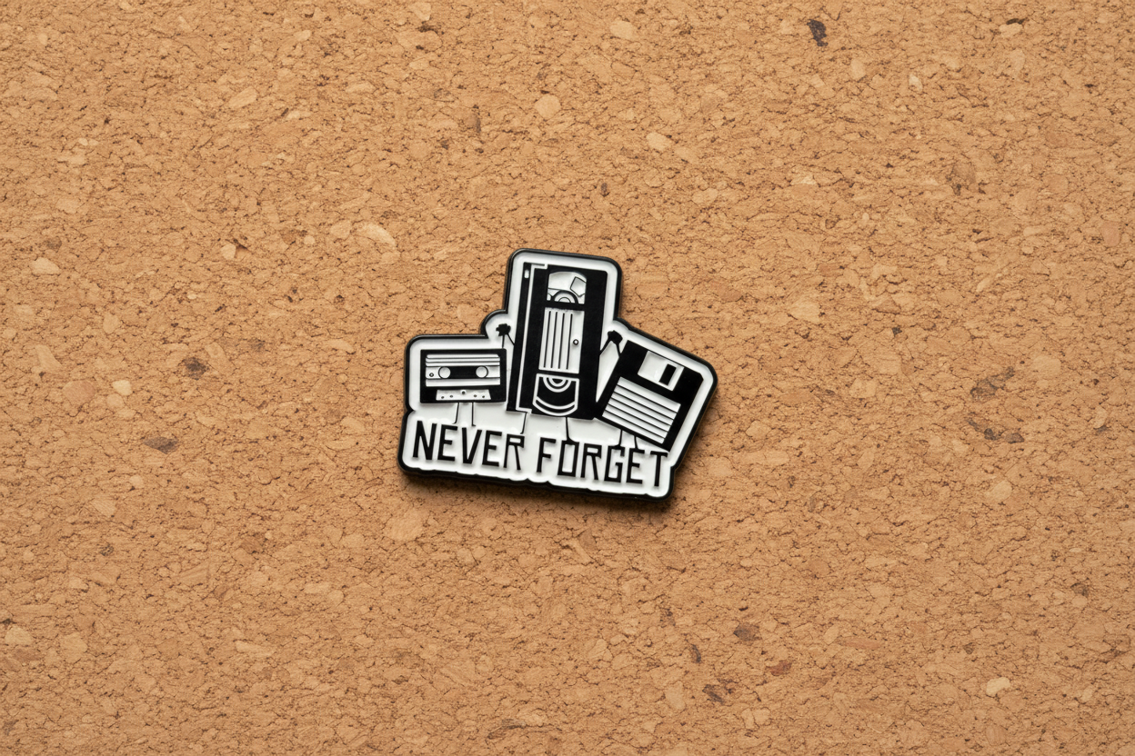 Pin with cassette tape design and 'Never Forget' text on a cork background