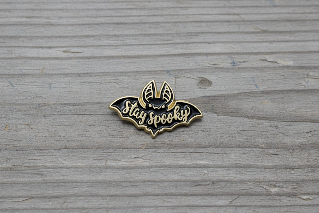 Stay Spooky Enamel Pin on wood background goth enamel pin with black and gold bat detail