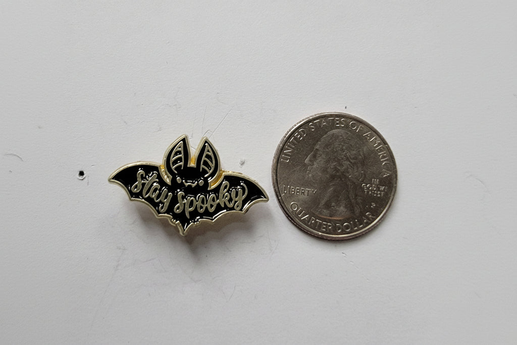 Stay Spooky Enamel Pin shown next to quarter for size reference witchy enamel pin dims 1 1/4 inch W x 1/2 in H