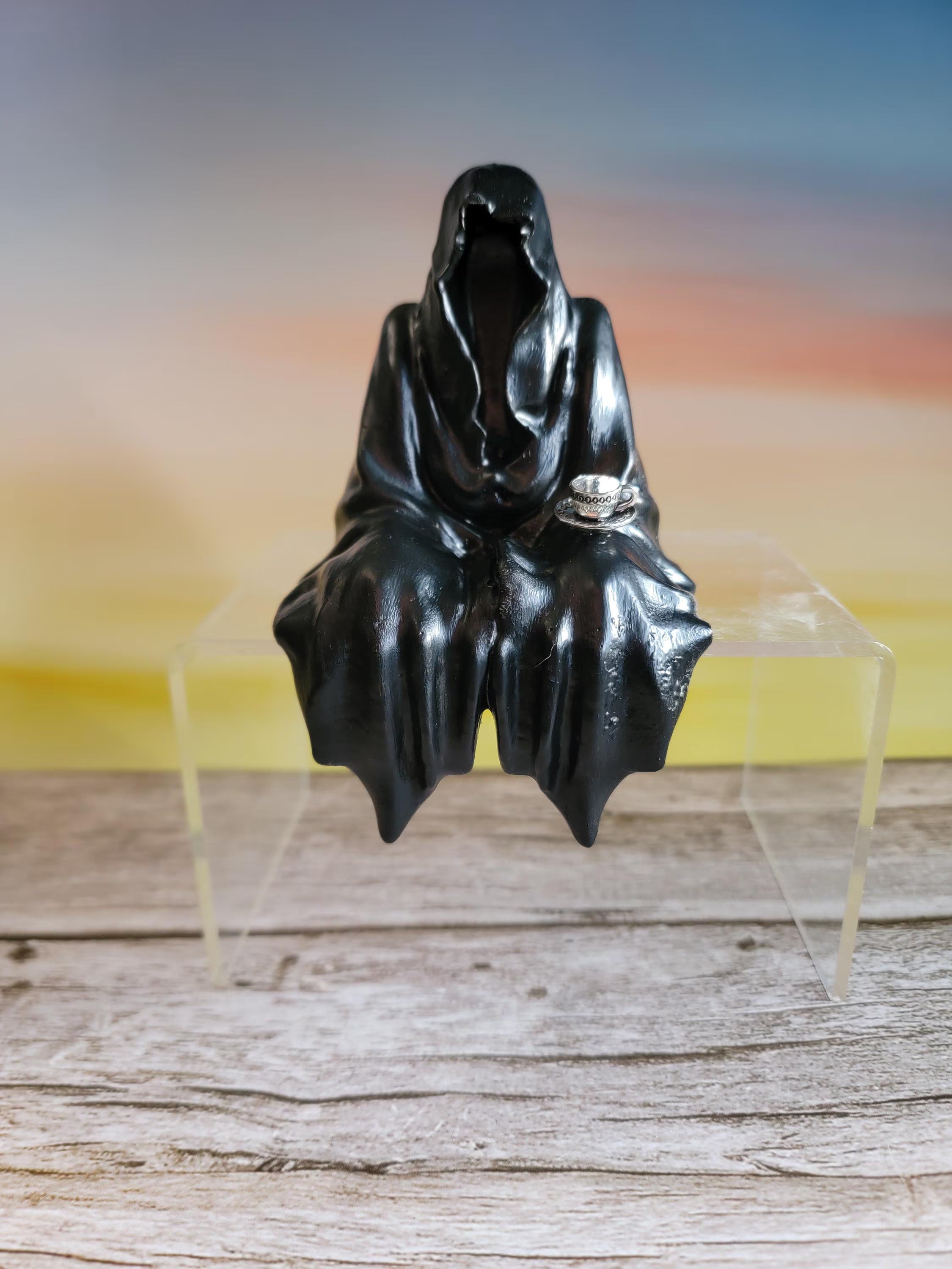 Black human shaped object on a clear stand with a white background