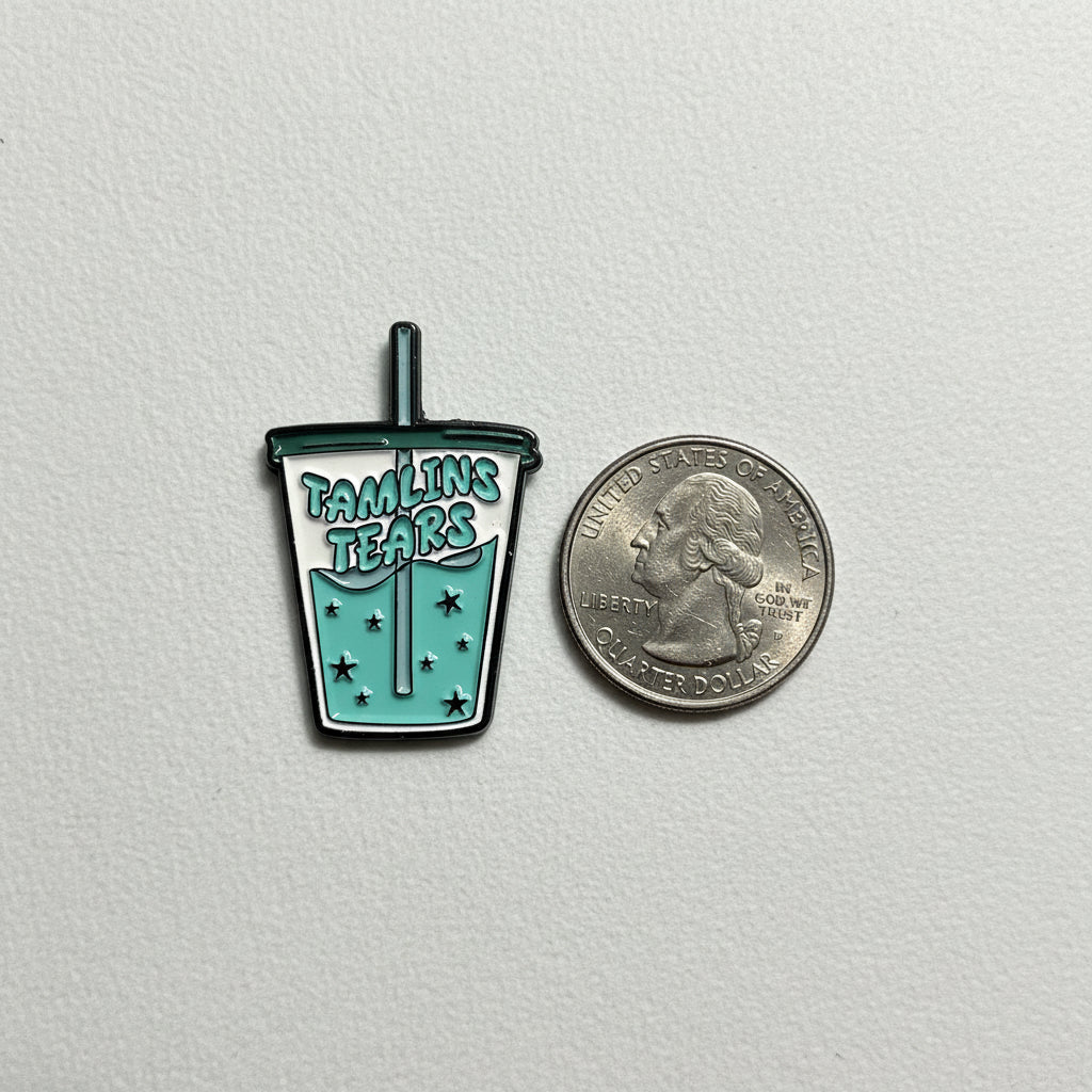 Tamlin's tears enamel pin shown next to quarter for size reference romantasy enamel pin dims 1.25 inches high X .75 inches wide