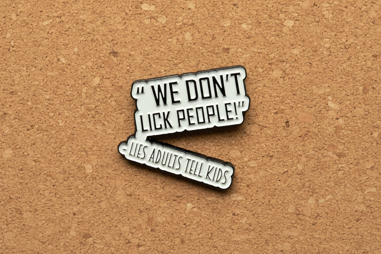 a white enamel pin with black text that says we don't lick people lies adults tell kids on a cork background