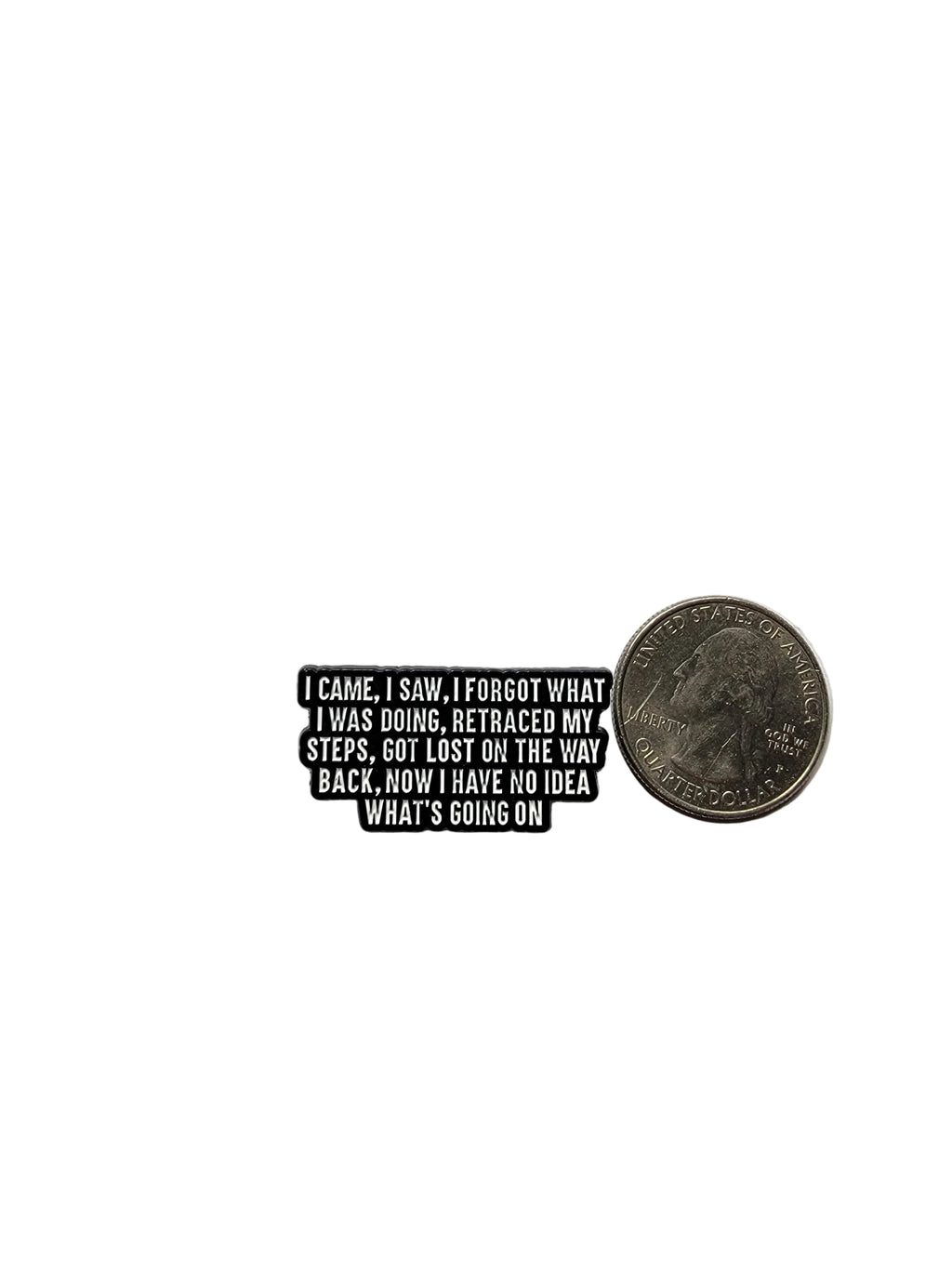 Small black and white enamel pin with text on a gray background