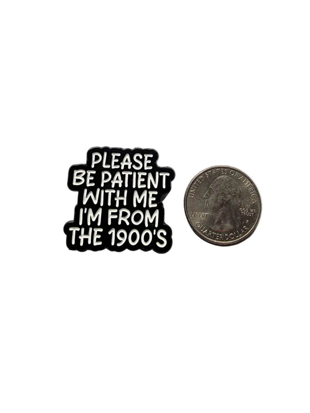 Black and white pin with text 'PLEASE BE PATIENT WITH ME I'M FROM THE 1900s' next to a coin on a gray background