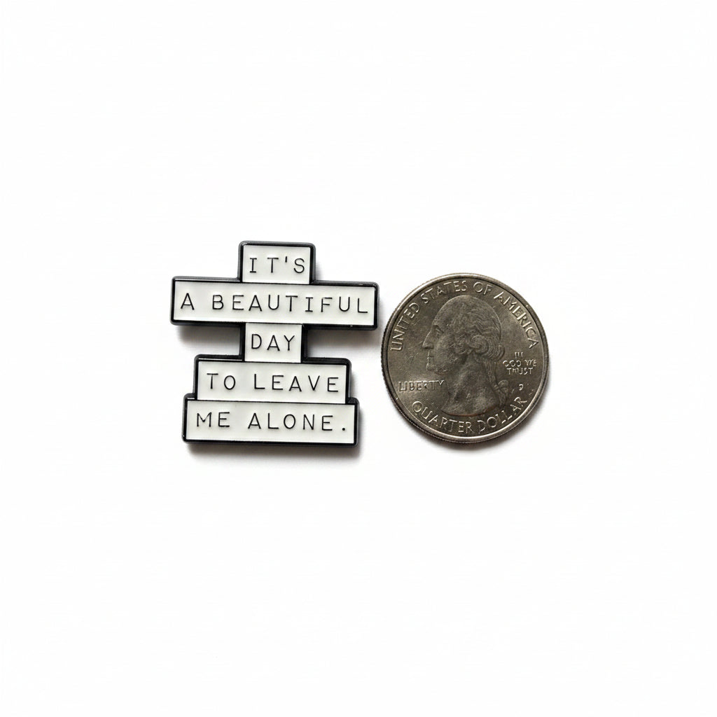 it's a beautiful day to leave me alone enamel pin shown next to quarter for size reference funny enamel pin dims 1 in W x 1 in H