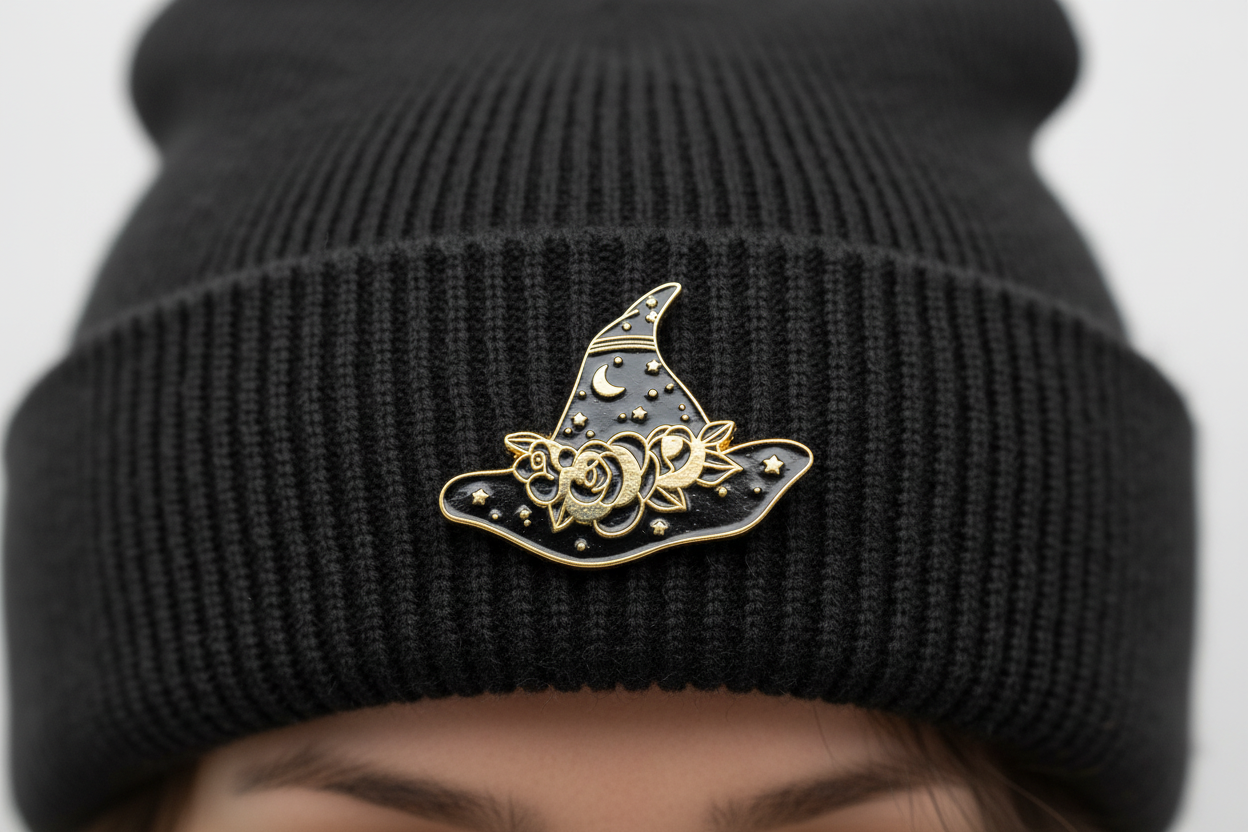 black and gold witch hat enamel pin worn on beanie hat alternative enamel pin for casual outfits and street wear