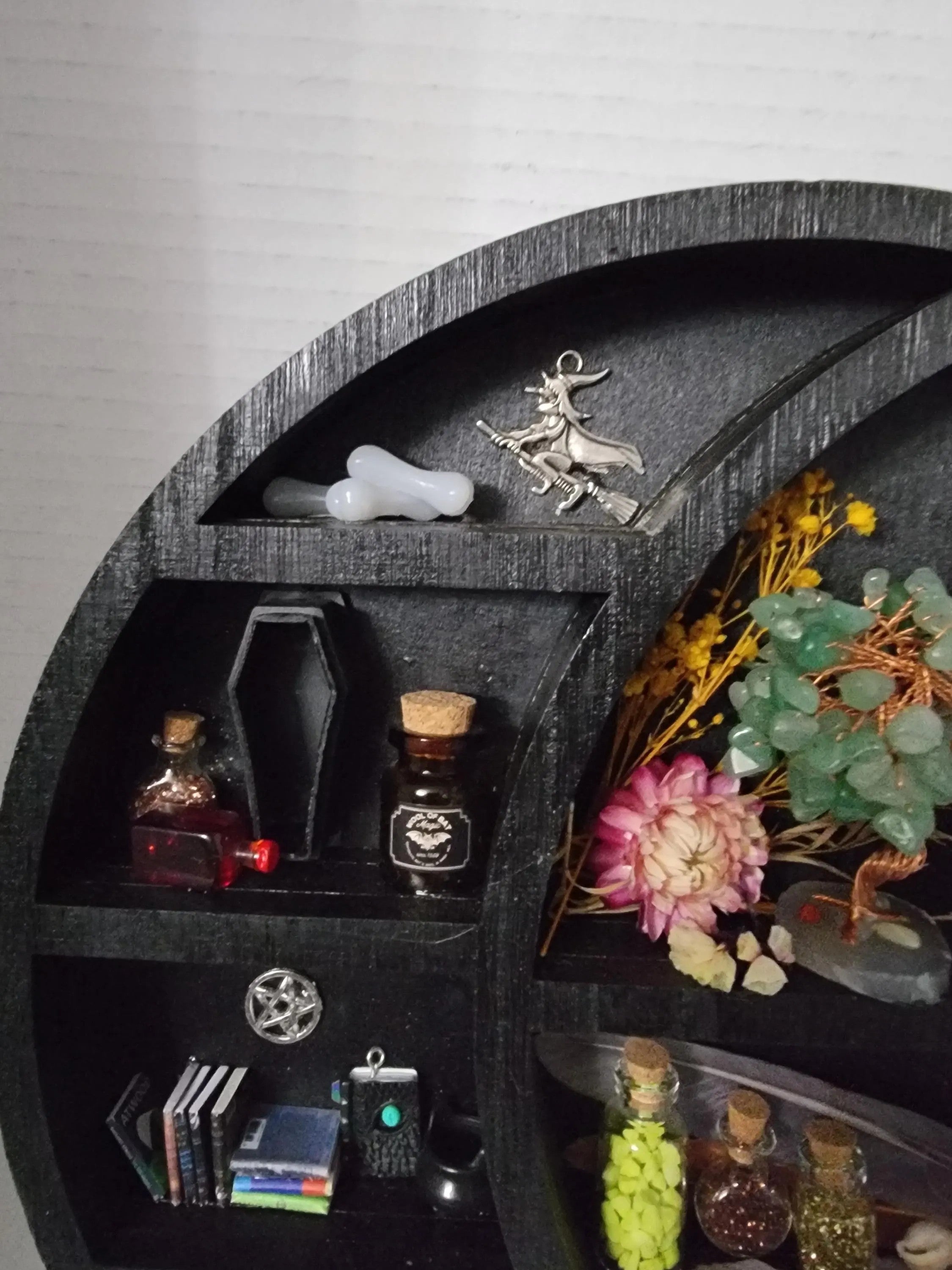 Decorative shelf with various items including bottles, a candle, and decorative elements.