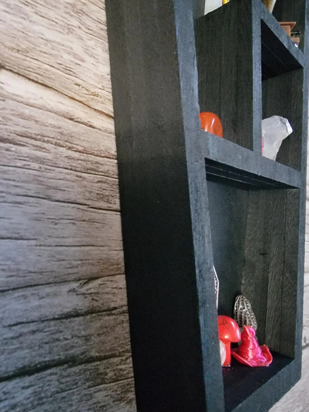 Black coffin box with compartments on a wooden surface