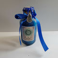 Blue bottle with a decorative label and ribbon on a white background