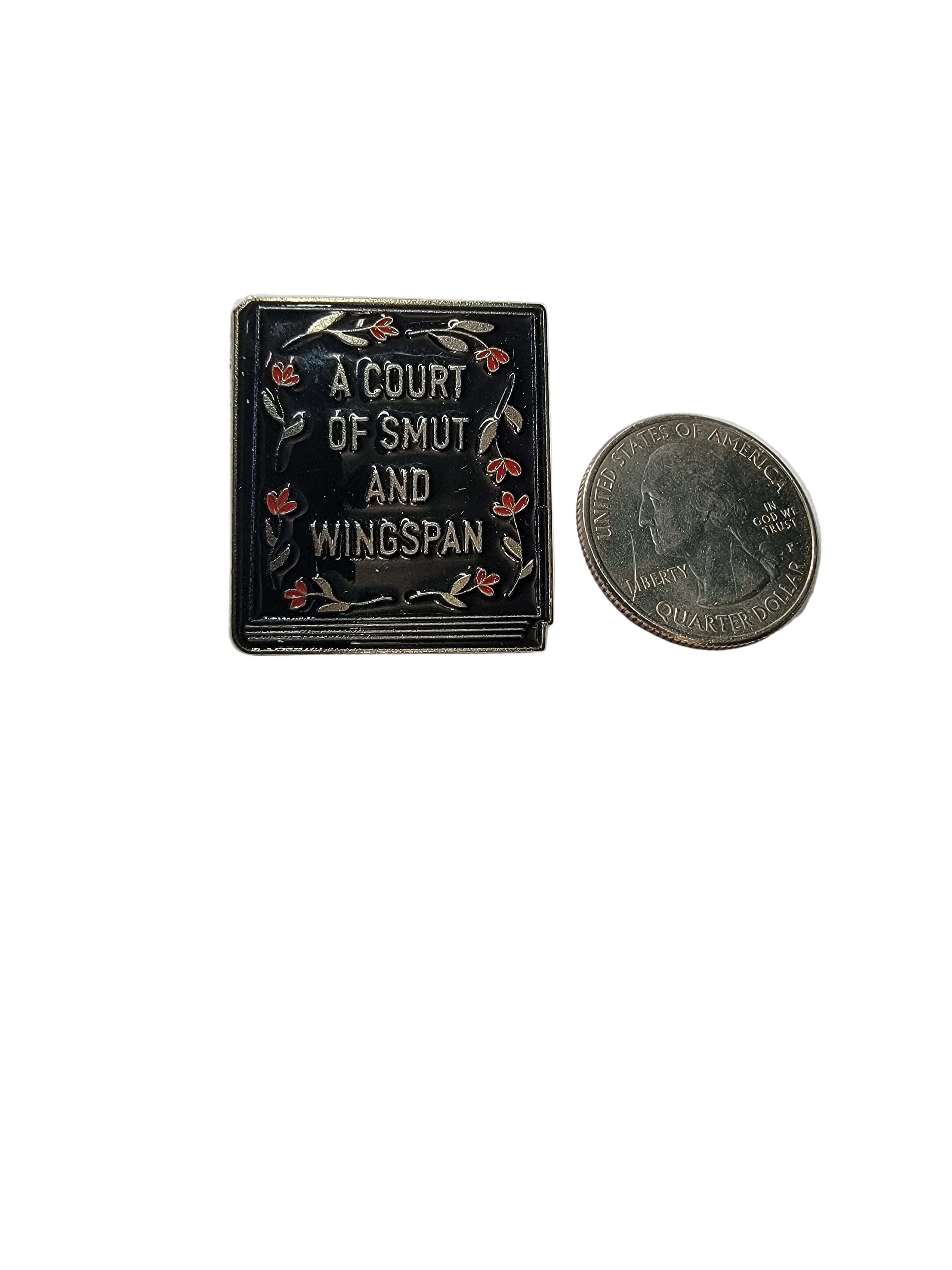 Small book with decorative cover and coin for scale on a white background