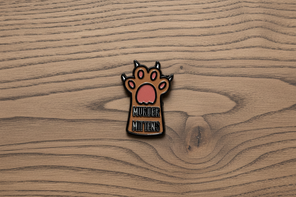 Small enamel pin with a paw design and text on a wood background