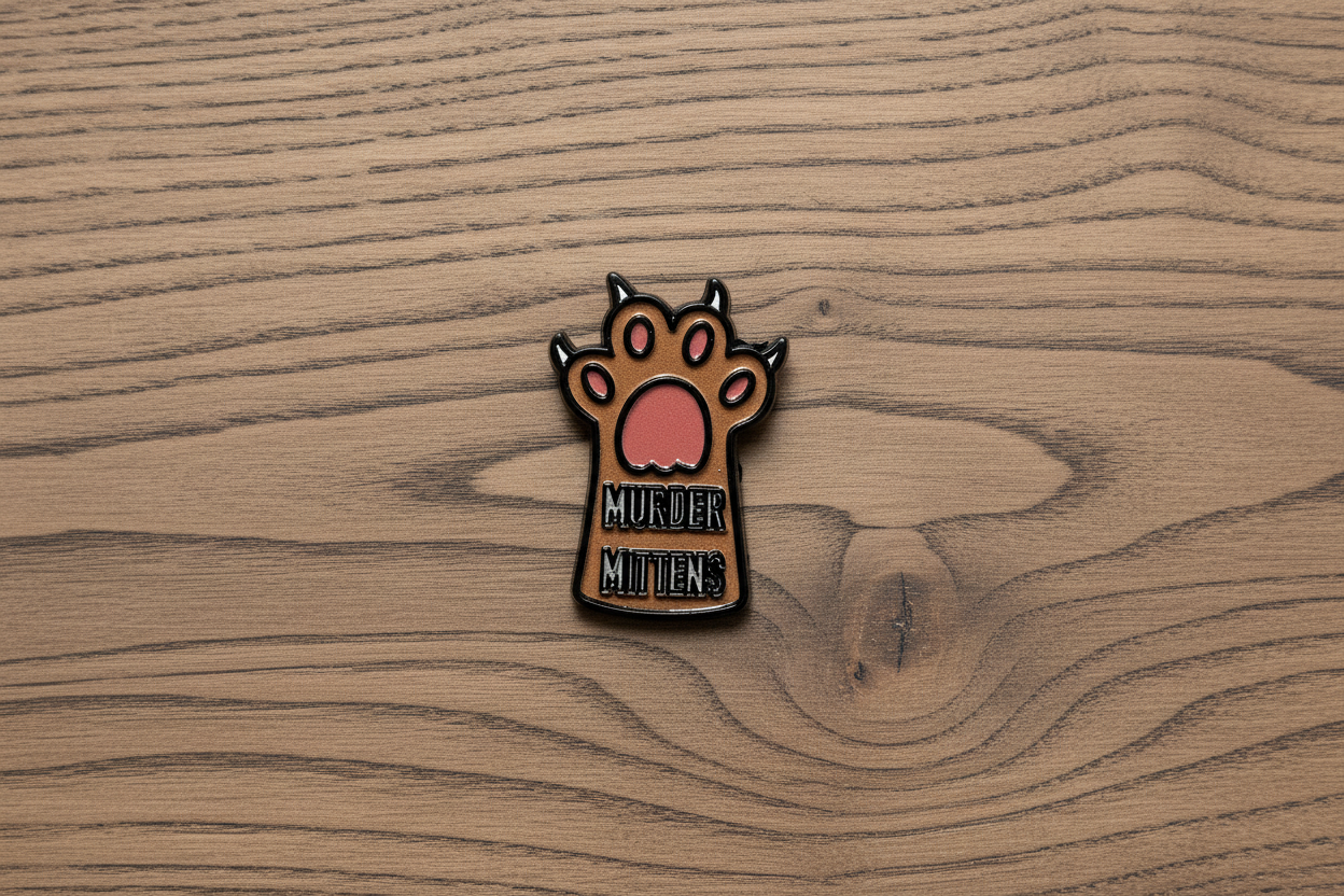 Small enamel pin with a paw design and text on a wood background