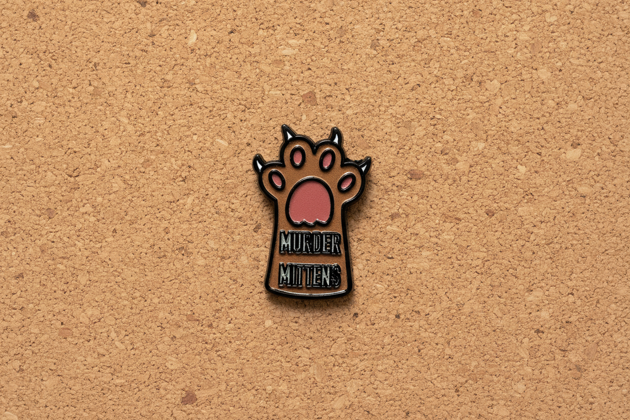 Small enamel pin with a paw design and text on a cork background