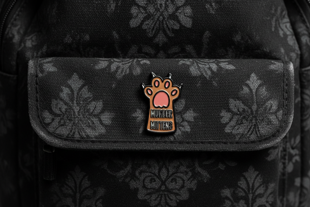 Small enamel pin with a paw design and text on a bookbag background