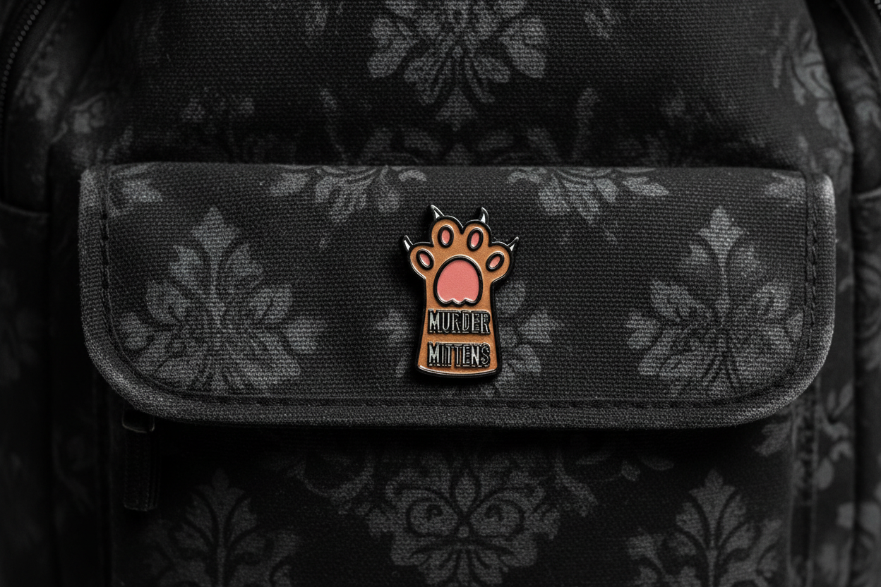 Small enamel pin with a paw design and text on a bookbag background