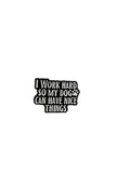 Black and white enamel pin with text on a gray background
