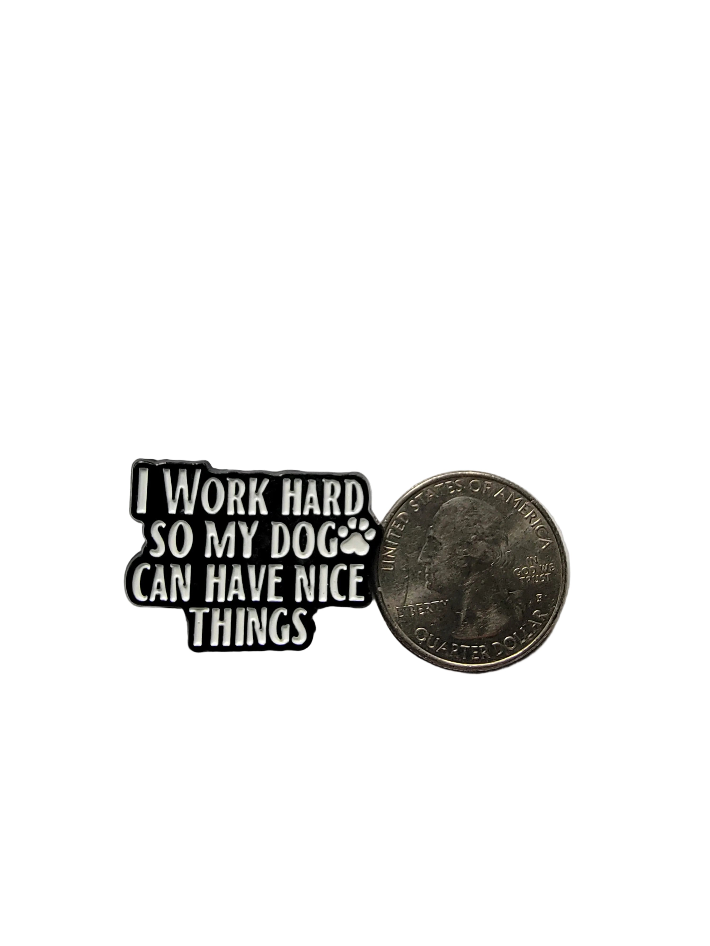Small black and white enamel pin with text on a gray background
