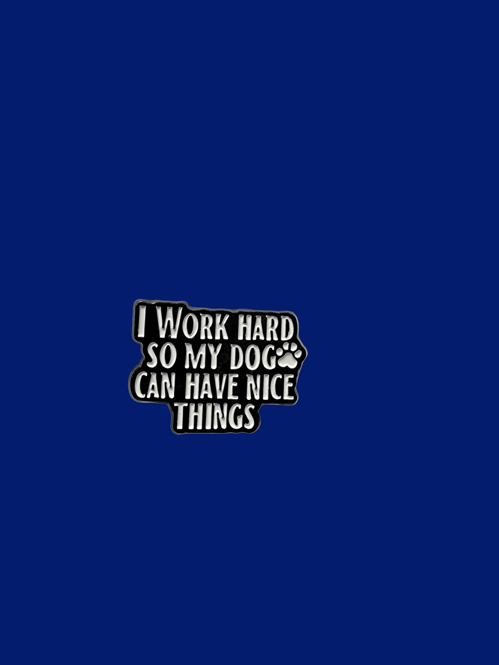 Black and white enamel pin with text on a blue background