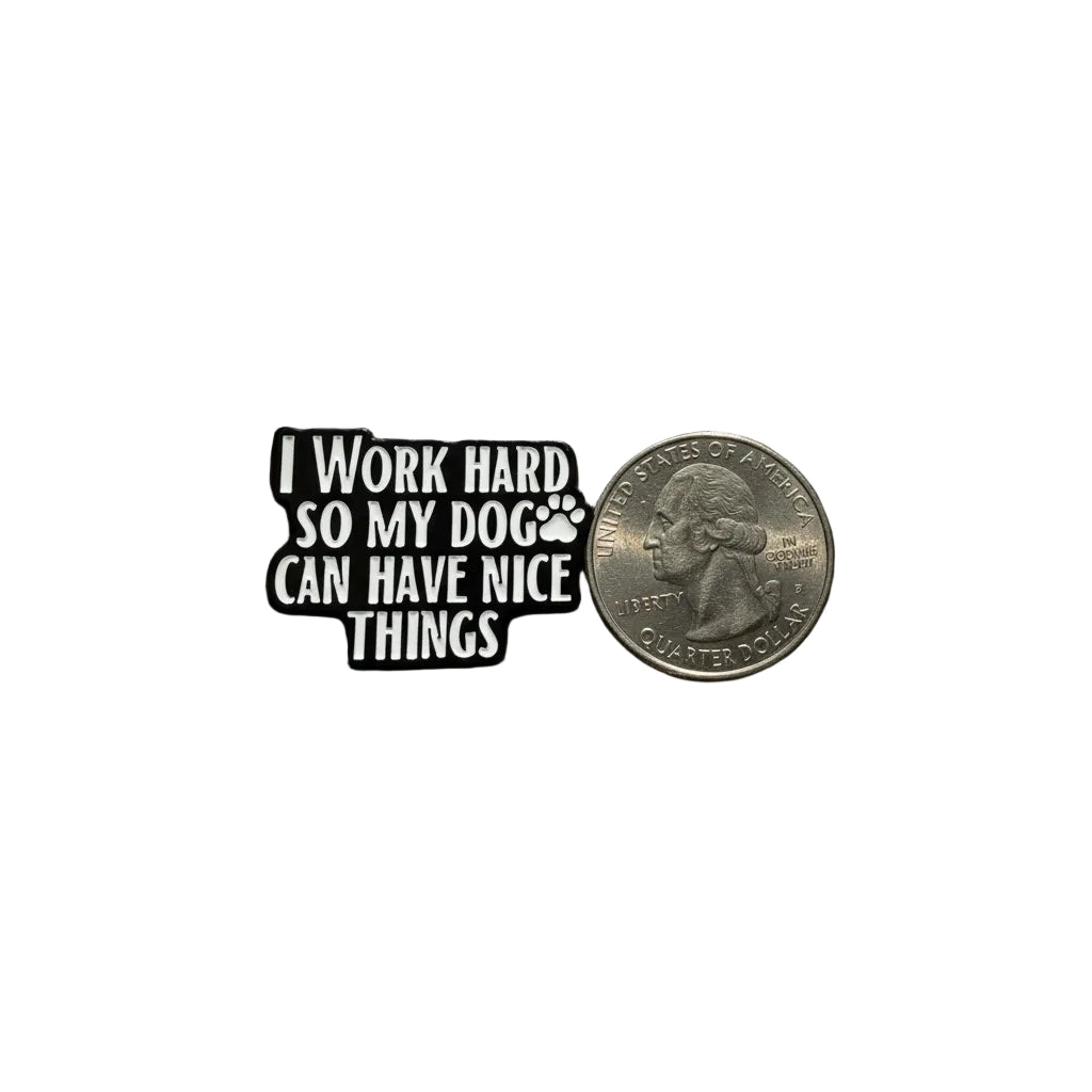 I work hard so my dog can have nice things enamel pin shown next to quarter for size reference dog enamel pin dims 1 1/8 in W x 7/8 in H