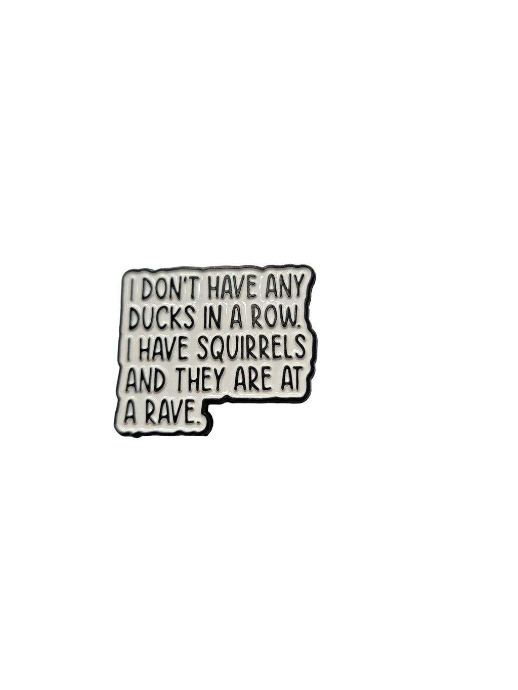 Enamel pin with humorous text on a plain background