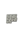 Enamel pin with humorous text on a plain background