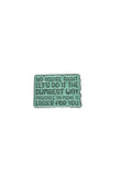 Green metal badge with text on a gray background