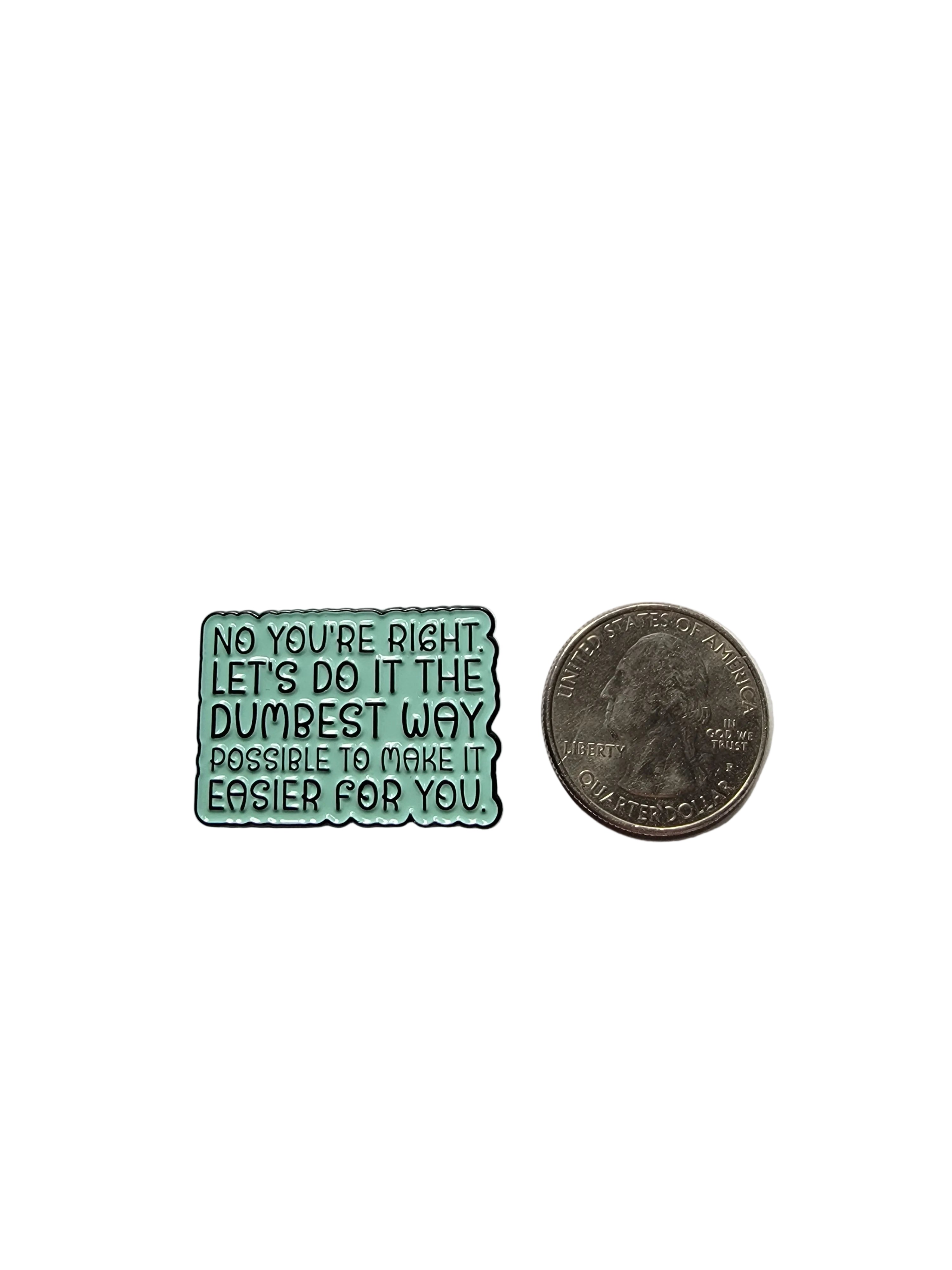 Small green metal object with text next to a quarter on a gray background
