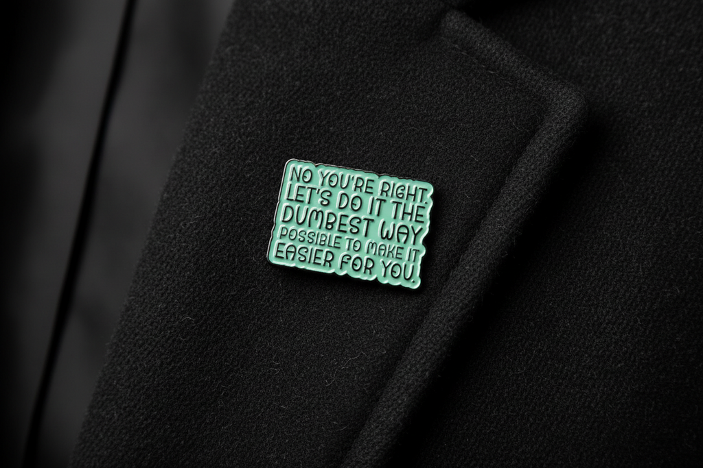 Green metal badge with text on a black fabric background
